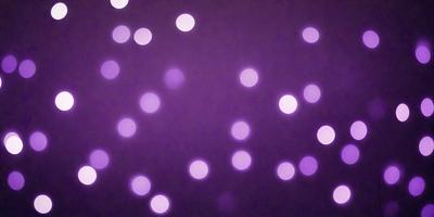 The primary subject of the image is a purple background with a pattern of white dots. The setting appears to be a dark room, and the visual style is a close-up of the purple background with the white dots. The colors and mood of the image are predominantly purple and dark, creating a moody and atmospheric scene.