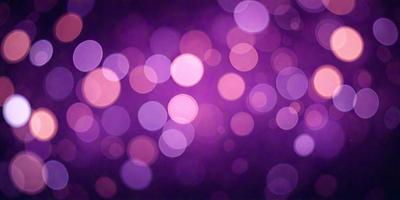 The primary subject of the image is a purple background with a pattern of bright, glowing lights. The setting appears to be a dark room, and the visual style is a combination of a photo and digital art. The colors and mood of the image are predominantly purple, with the glowing lights adding a sense of warmth and energy to the scene.