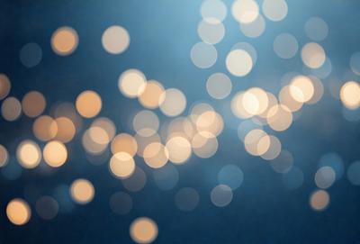The primary subject of the image is a brightly lit background featuring a large number of small, bright lights. The setting appears to be a dark room, and the visual style is a combination of a photo and digital art. The colors and mood of the image are predominantly bright and lively, with the lights creating a vibrant and energetic atmosphere.
