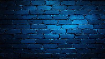 The primary subject of the image is a brick wall. The setting is a dark room with a blue brick wall, which creates a moody atmosphere. The visual style is a photo, and the dominant colors are blue and grey.