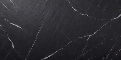 The primary subject of the image is a black marble countertop. The setting is a kitchen, with the countertop being the main focus of the scene. The visual style is a close-up of the marble countertop, showcasing its texture and details. The colors and mood of the image are predominantly dark, with the black marble countertop being the main source of contrast and visual interest.