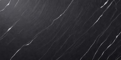 The primary subject of the image is a black marble countertop. The setting is a kitchen, with the countertop being the main focus of the scene. The visual style is a close-up of the marble countertop, showcasing its texture and pattern. The colors and mood of the image are predominantly dark, with the black marble countertop being the main source of contrast.