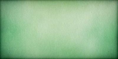 The primary subject of the image is a green background. The setting is a large, empty space with no visible objects or people. The visual style is a close-up of the green background, which appears to be a piece of paper or a fabric. The colors and mood of the image are predominantly green, creating a calm and serene atmosphere.