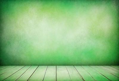 The primary subject of the image is a green wall with a wooden floor. The setting is a room with a green background, and the visual style is a photo. The dominant colors are green and white, creating a calm and serene atmosphere.