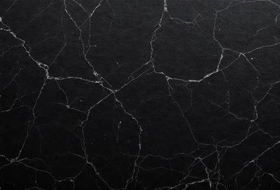 The primary subject of the image is a black marble wall with a pattern of white spots. The setting is a room with a black background, and the visual style is a close-up of the marble wall. The dominant colors are black and white, creating a contrasting and elegant atmosphere.