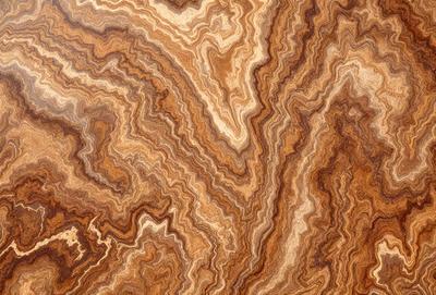 The primary subject of the image is a close-up of a wooden surface with a unique and intricate pattern. The setting is a wooden table, and the visual style appears to be a close-up of a natural texture. The colors and mood of the image are warm and earthy, with the wooden surface showcasing the natural beauty of the wood grain.