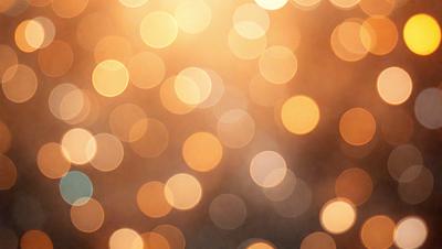 The primary subject of the image is a bright, colorful, and blurry background featuring a pattern of yellow and orange lights. The setting appears to be a nighttime cityscape, with the lights creating a vibrant and lively atmosphere. The visual style of the image is a combination of photo and digital art, as it captures the vivid colors and motion of the lights. The colors and mood of the image are predominantly warm and energetic, with the yellow and orange lights creating a sense of excitement