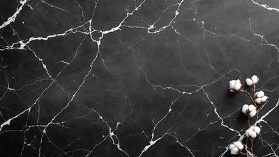The image features a black and white marble wall with a pattern of white and grey veins. The wall appears to be a part of a bathroom, as it is described as a "bathroom wall." The black and white color scheme creates a classic and elegant atmosphere.