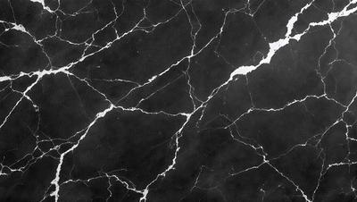 The primary subject of the image is a black marble countertop with a white vein running through it. The setting is a kitchen, and the visual style is a close-up of the marble countertop. The colors and mood of the image are predominantly black and white, with the white vein adding a touch of contrast and interest to the otherwise dark surface.