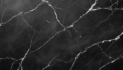 The image features a black and white marble wall with a pattern of white lines. The wall appears to be a part of a building, possibly a bathroom or a kitchen. The black and white color scheme gives the scene a classic and elegant appearance.