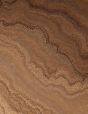 The primary subject of the image is a wooden table with a brown and tan marbled surface. The setting is a room with a wooden floor. The visual style is a close-up of the wooden table, showcasing its unique texture and pattern. The colors and mood of the image are warm and natural, with the brown and tan marbled surface creating a sense of warmth and comfort.