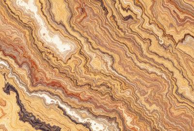 The primary subject of the image is a close-up of a marble stone with a unique and intricate pattern. The setting is a natural environment, with the marble stone being the main focus of the image. The visual style is a close-up of the marble, showcasing its texture and details. The colors and mood of the image are predominantly earthy tones, giving it a natural and organic feel.