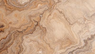 The image features a marble-like surface with a pattern of swirls and grooves. The primary subject is the marble, which is the main object, scene, or focus of the image. The setting is a natural environment, with the marble surface being the backdrop. The visual style is a close-up of the marble, showcasing its intricate pattern. The colors and mood of the image are predominantly earthy tones, giving it a natural and elegant appearance.