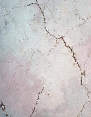 The primary subject of the image is a close-up of a marble wall with a cracked and chipped appearance. The setting is a room with a marble surface, and the visual style is a close-up of the wall. The colors and mood of the image are predominantly white, with some pink and brown tones, giving it a somewhat aged and worn appearance.