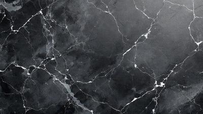 The image features a black and white marble wall with a pattern of white lines. The wall appears to be a part of a building, possibly a bathroom or a kitchen. The overall atmosphere of the image is elegant and sophisticated, with the contrasting black and white colors adding a touch of timelessness.