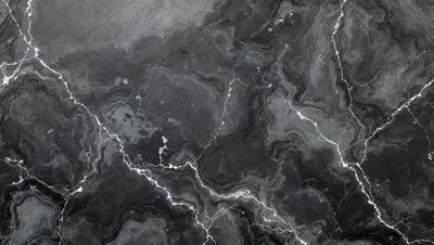 The primary subject of the image is a marble surface with a pattern of light and dark streaks. The setting is a black and white photo, which gives the image a classic and timeless appearance. The visual style is a close-up of the marble surface, highlighting the intricate pattern of the light and dark streaks. The colors and mood of the image are predominantly black and white, creating a sense of depth and contrast.