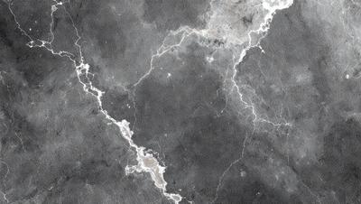 The image features a black and white marble wall with a pattern of light and dark streaks. The wall appears to be textured and has a unique design. The primary subject of the image is the marble wall, which serves as the main focus of the scene. The setting is a room with the marble wall as the background, creating a striking contrast between the wall and the rest of the space. The visual style of the image is a combination of photo and digital art, as it captures the intricate details of the marble