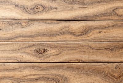 The primary subject of the image is a wooden floor with a unique and intricate pattern. The setting is a room with a wooden floor, and the visual style appears to be a close-up of the wooden surface. The colors and mood of the image are warm and natural, with the wooden floor being the main focus.