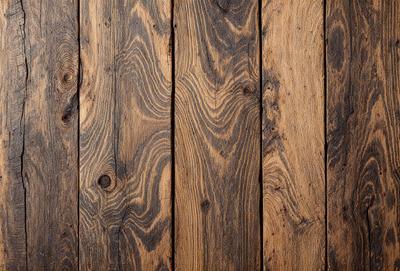The primary subject of the image is a wooden floor with a unique and intricate pattern. The setting is a room with a wooden floor, and the visual style is a close-up of the wooden floor. The colors and mood of the image are warm and natural, with the wooden floor being the main focus.