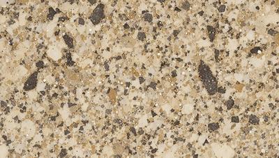 The primary subject of the image is a close-up of a marble countertop. The setting is a kitchen, with the countertop being the main focus of the scene. The visual style is a photo, capturing the natural texture and beauty of the marble surface. The colors and mood of the image are predominantly neutral, with the marble providing a warm and elegant atmosphere.
