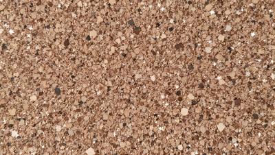 The primary subject of the image is a close-up of a brown, textured surface, possibly a wall or a piece of fabric. The setting appears to be a room with a brown color scheme. The visual style of the image is a close-up, which emphasizes the texture and details of the surface. The colors and mood of the image are warm and earthy, creating a cozy and inviting atmosphere.