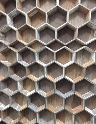 The primary subject of the image is a wooden wall with a unique pattern of hexagonal shapes. The setting is a room with a wooden floor, and the visual style appears to be a combination of a photo and a digital art or illustration. The dominant colors are brown and white, creating a warm and natural atmosphere.