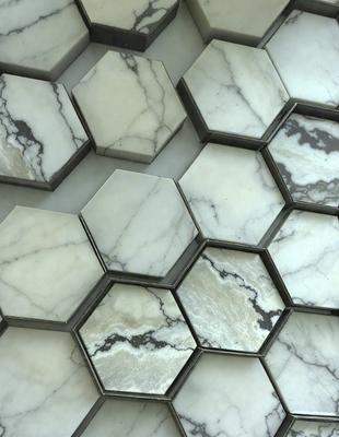 The image features a marble tile pattern with a white and grey color scheme. The tiles are arranged in a hexagonal pattern, creating a visually appealing and textured surface. The overall atmosphere of the image is elegant and sophisticated, with the marble tiles adding a touch of luxury and refinement to the setting.