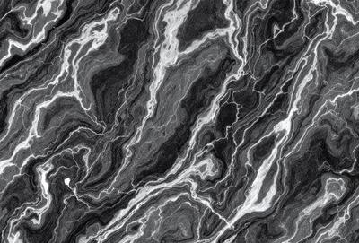 The primary subject of the image is a marble surface with a black and white pattern. The setting is a stone wall, and the visual style is a close-up of the marble pattern. The colors and mood of the image are predominantly black and white, giving it a classic and elegant appearance.