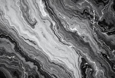 The image features a close-up of a marble surface with a unique, textured pattern. The marble appears to be a mix of black and white, creating a striking contrast. The pattern on the marble surface is intricate and eye-catching, making it an interesting focal point in the image.