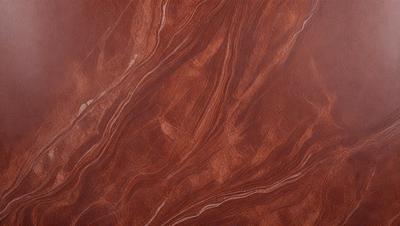 The primary subject of the image is a close-up of a marbled surface, which appears to be a piece of wood or a stone. The setting is a room with a wooden floor, and the visual style is a close-up of the marbled surface. The colors and mood of the image are predominantly brown, giving it a warm and natural appearance.