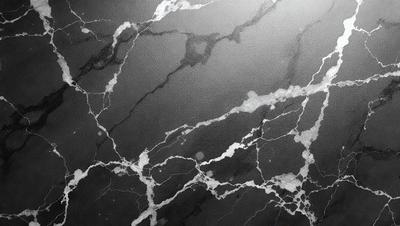 The primary subject of the image is a black and white photo of a marble wall. The setting is a dark room, and the visual style is a close-up of the marble wall. The colors and mood of the image are predominantly dark, with the marble wall being the main focus.