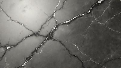 The primary subject of the image is a marble countertop with a cracked and textured surface. The setting is a kitchen or bathroom environment, with the countertop being the main object of focus. The visual style is a black and white photo, which adds a sense of timelessness and elegance to the scene. The colors and mood of the image are predominantly dark, with the cracked marble surface adding a sense of depth and character to the countertop.