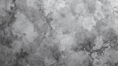 The primary subject of the image is a gray stone wall. The setting is a stone wall with a patterned texture, giving it a unique and textured appearance. The visual style of the image is a close-up of the stone wall, showcasing its intricate details. The colors and mood of the image are predominantly gray, giving it a calm and serene atmosphere.