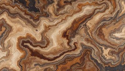 The primary subject of the image is a close-up of a wooden surface with a unique and intricate pattern. The setting is a wooden table, and the visual style appears to be a close-up of a natural material. The colors and mood of the image are warm and earthy, with the wooden surface showcasing its natural texture and patterns.