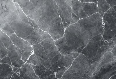 The image features a black and white marble wall with a pattern of white and gray veins. The wall appears to be a part of a building, possibly a bathroom or a kitchen. The marble pattern creates a unique and elegant appearance, adding a touch of sophistication to the space.