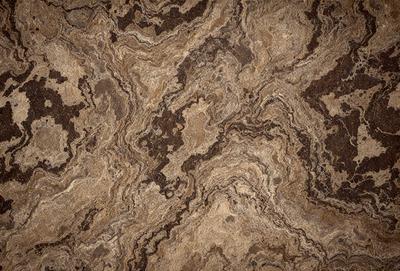 The primary subject of the image is a marble tile with a brown and white pattern. The setting is a room with a brown and white marble floor. The visual style is a close-up of the marble tile, showcasing its intricate design. The colors and mood of the image are warm and earthy, with the brown and white marble creating a natural and elegant atmosphere.