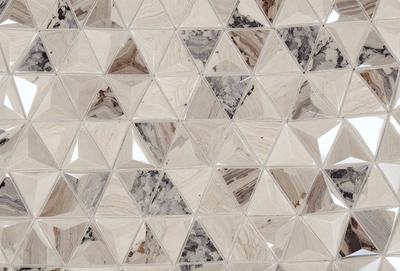 The primary subject of the image is a large, intricate, and textured wall made of marble. The setting is a room with a white background, which highlights the marble wall. The visual style is a combination of a photo and digital art, creating a unique and artistic representation of the marble wall. The colors and mood of the image are predominantly white and neutral, giving the scene a clean and elegant appearance.