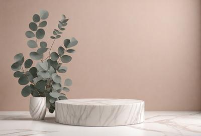 The primary subject of the image is a white marble table with a round, white marble top. The table is placed on a white surface, which could be a table or a countertop. The setting is a room with a wall in the background. The visual style is a photo, capturing the details of the marble table and its surroundings. The colors and mood of the image are predominantly white, giving it a clean and elegant appearance.