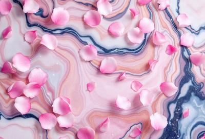 The primary subject of the image is a close-up of a pink flower. The setting is a marbled surface, which adds a unique texture to the scene. The visual style is a close-up of the flower, emphasizing its details and beauty. The dominant colors in the image are pink and white, creating a soft and delicate atmosphere.