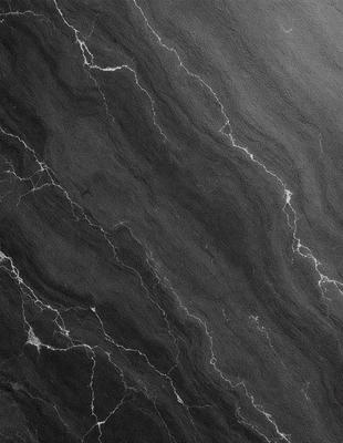 The primary subject of the image is a close-up of a black marble surface. The setting is a dark room, and the visual style is a black and white photo. The dominant colors are black and white, creating a moody and dramatic atmosphere.