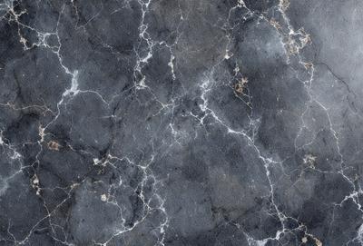 The primary subject of the image is a marble wall with a pattern of holes and bumps. The setting is a room with a black and white marble floor. The visual style is a close-up of the marble wall, showcasing its unique texture and pattern. The colors and mood of the image are predominantly black and white, giving it a classic and elegant appearance.