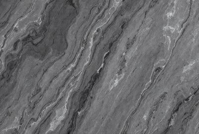 The primary subject of the image is a close-up of a marble surface with a pattern of swirls and grooves. The setting is a dark room, and the visual style appears to be a black and white photo. The colors and mood of the image are predominantly dark and moody, with the marble surface serving as the focal point.