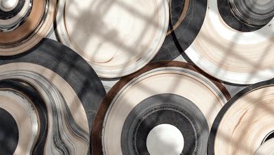 The primary subject of the image is a collection of white and brown plates. The plates are arranged in a visually appealing manner, creating a sense of harmony and balance. The setting is a room with a window, which allows natural light to illuminate the scene. The visual style of the image is a combination of photo and digital art, giving it a unique and artistic appearance. The colors and mood of the image are predominantly neutral, with the white plates and brown accents creating a sense of warmth
