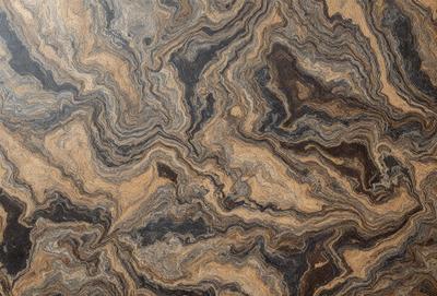 The primary subject of the image is a close-up of a marble-like patterned wood grain. The setting is a wooden surface, possibly a table or a countertop. The visual style is a close-up of the wood grain, showcasing the intricate patterns and textures. The colors and mood of the image are warm and natural, with the wooden surface appearing rich and inviting.