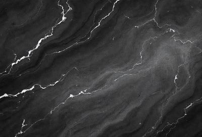 The primary subject of the image is a black and white marble pattern. The setting is a black background, which contrasts with the marble pattern. The visual style is a close-up of the marble pattern, showcasing its intricate details. The colors and mood of the image are predominantly dark, with the marble pattern being the main focus.