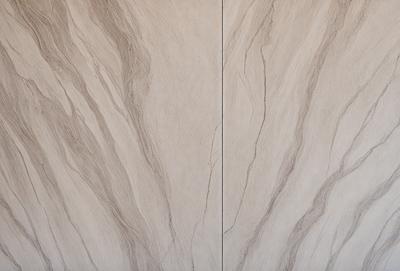 The primary subject of the image is a wall with a marble texture. The setting is a room with a white color scheme. The visual style is a close-up of the wall, showcasing the marble texture. The colors and mood of the image are predominantly white, giving it a clean and elegant appearance.