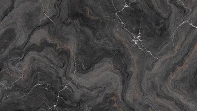 The primary subject of the image is a close-up of a marble countertop. The setting is a kitchen, with the marble countertop being the main focus of the scene. The visual style is a photo, capturing the intricate details of the marble surface. The colors and mood of the image are predominantly dark, with the marble countertop being the main source of light and contrast.