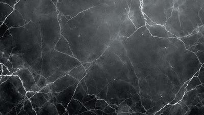 The primary subject of the image is a black and white photo of a marble surface. The setting is a black and white background, which adds a classic and timeless feel to the photo. The visual style is a close-up of the marble surface, showcasing its texture and details. The colors and mood of the image are predominantly black and white, giving it a sophisticated and elegant appearance.