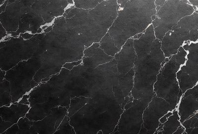 The primary subject of the image is a black marble wall with a pattern of white spots. The setting is a room with a black marble floor. The visual style is a close-up of the marble wall, showcasing its unique texture and pattern. The colors and mood of the image are predominantly black and white, giving it a classic and elegant appearance.