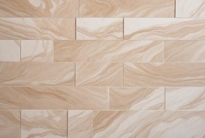 The primary subject of the image is a wall made of tiles, featuring a unique and intricate design. The setting is a room with a tile wall, and the visual style appears to be a combination of photo and digital art. The dominant colors in the image are beige and brown, creating a warm and earthy atmosphere.